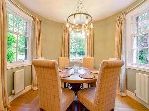 a dining room with a table and chairs and windows at West Lodge in Perth