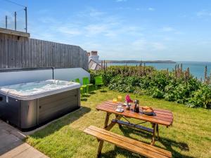 Un jardín con una mesa y un jacuzzi. en Beachbreak - Uk42996, en Woolacombe