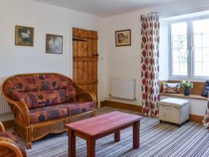 a living room with a couch and a table at Pickled Onion Cottage in Taunton