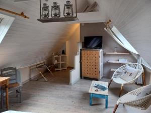 une pièce avec un escalier avec une télévision et des chaises dans l'établissement Le Colombier Bretagne, à Louannec