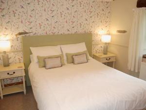 ein Schlafzimmer mit einem großen weißen Bett mit zwei Lampen in der Unterkunft Garden Cottage in Pooley Bridge + 7 Fotos