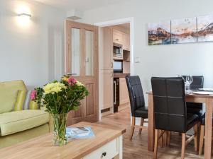 a living room with a vase of flowers on a table at Chapel Mouse Cottage in Cockermouth