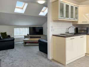 a kitchen with white cabinets and a living room at Regent House in Scarborough +6 photos