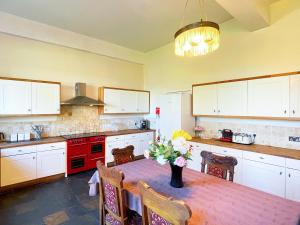a kitchen with a table with a vase of flowers on it at The Mansion House At Kirkhill in Arniston