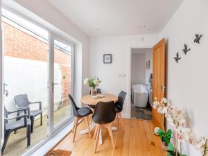 a dining room with a table and chairs and a bathroom at Pebble Cottage in Cullercoats