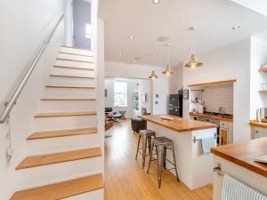 a kitchen and living room with a staircase in a house at Pebble Cottage in Cullercoats +16 photos