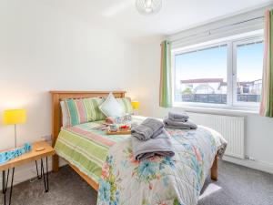 Un dormitorio con dos camas y una ventana. en Swn Y Mor, en Trearddur