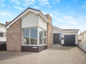 una casa blanca con un muro de piedra en Swn Y Mor, en Trearddur
