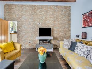 ein Wohnzimmer mit Sofa und Fernseher in der Unterkunft Blofield Cottage - Uk48095 in Norwich
