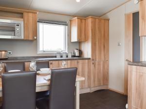 a kitchen with a table with chairs and a microwave at Peachy in Heysham