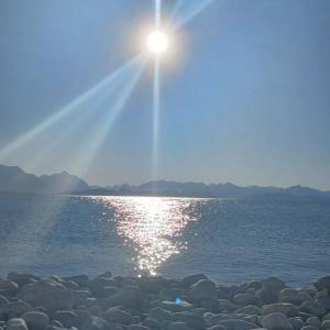 un sol brillando sobre un cuerpo de agua en Luz del Nahuel, en San Carlos de Bariloche