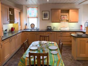a kitchen with a table with chairs in it at The Coyles - Uk31466 in Ballater
