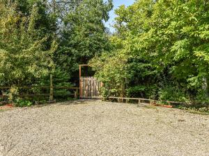 a gate in a yard with a fence and trees at The Cottage At Dockens Water in Fritham