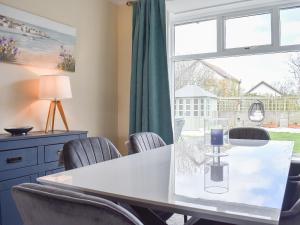 a dining room with a table and chairs and a window at Och Moo At Number 47 in Seahouses