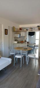 Un comedor con mesas y sillas y una cocina. en Luz del Nahuel, en San Carlos de Bariloche