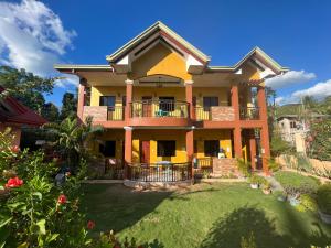 a large house with a yard at Sangi Tourist Inn near Kawasan Badian Canyoneering in Alegria