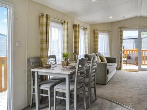 a dining room with a table and chairs and a couch at Lodge 43 Bridlington Holiday Park - Uk47517 in Carnaby