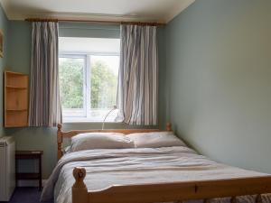 ein Schlafzimmer mit einem Bett vor einem Fenster in der Unterkunft Bear Cottage in Abbey Dore