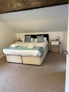 a bedroom with a large bed with blue pillows at Dunsdale Lodge in Frodsham