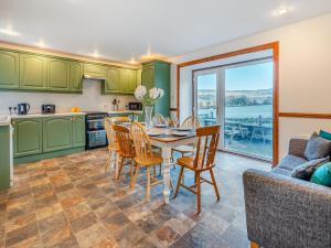 a kitchen and dining room with a table and chairs at Balnamuir Farmhouse in Pitlochry