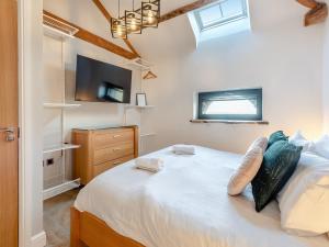 a bedroom with a large bed and a tv at The Barn Owl - Uk36217 in Bowness-on-Solway