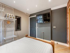 a bedroom with a bed and a tv on the wall at The Barn Owl - Uk36217 in Bowness-on-Solway