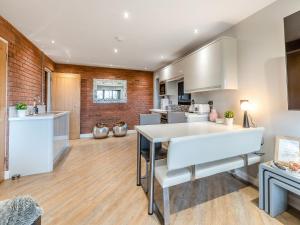 a kitchen with white appliances and a brick wall at The Barn Owl - Uk36217 in Bowness-on-Solway