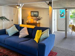 a blue couch with colorful pillows in a living room at Osokozy Cottage in Shrawley