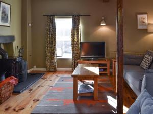 a living room with a couch and a tv at Letterbox Cottage in Far Sawrey