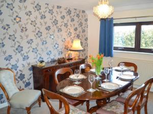 a dining room with a wooden table and chairs at Angerton Cottage in Kirklinton +11 photos