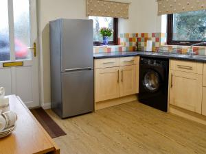 a kitchen with a stainless steel refrigerator and a dishwasher at Angerton Cottage in Kirklinton