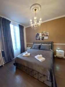 a bedroom with a large bed with two towels on it at Villa Napoleon in Les Lilas