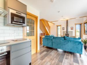 eine Küche mit blauem Sofa in einem Zimmer in der Unterkunft The Larches - Uk46804 in Culbokie + 16 Fotos