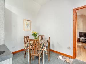 Un comedor con una mesa y dos sillas. en The Coyles Cottage - Sbh, en Ballater