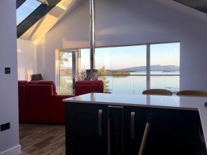a kitchen and living room with a view of the water at Tidereach - Otters View - Uk12269 in Connel