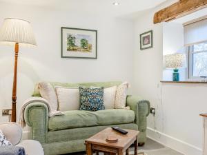 a living room with a green couch and a table at Clarence Cottage - Uk47494 in Waterfall