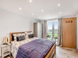 a bedroom with a large bed and a balcony at Bracken Cottage in Alston