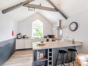 a kitchen with a counter and a clock on the wall at Bracken Cottage in Alston