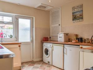a kitchen with a washing machine and a window at Sea Dog Cottage in Scarborough