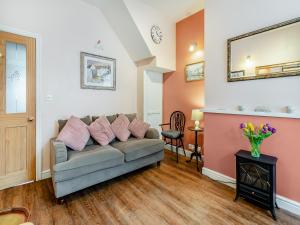a living room with a couch and a mirror at Sea Dog Cottage in Scarborough