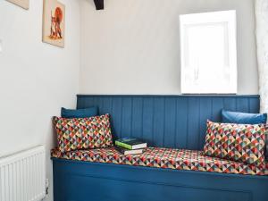 eine blaue Bank mit Büchern auf einem Zimmer in der Unterkunft The Cottage - Uk35177 in Abbots Bickington
