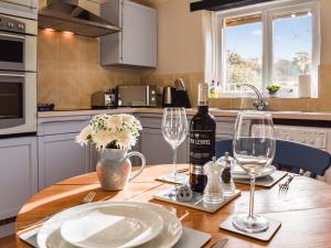 ein Tisch mit einer Flasche Wein und zwei Gläsern in der Unterkunft The Cottage - Uk35177 in Abbots Bickington