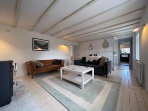 a living room with a couch and a table at Lower Hilton Cottage in Culrain