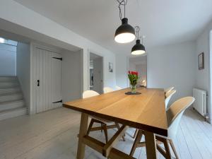 a dining room with a wooden table and white chairs at Lower Hilton Cottage in Culrain +24 photos