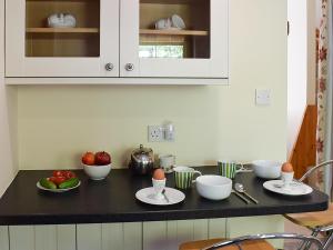 a kitchen counter with bowls and plates of food on it at Little Tigh Craggan - Uk10204 in Weem