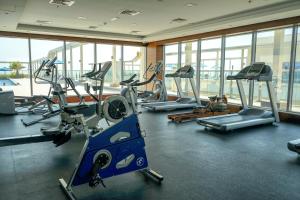 a gym with several treadmills and elliptical machines at Marjan Lux Homes in Ras al Khaimah