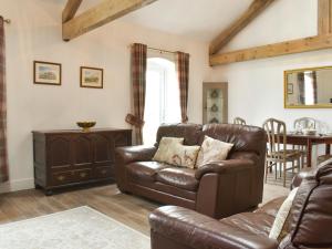 a living room with a leather couch and a table at Apple Tree Barn- Uk40791 in Church Minshull