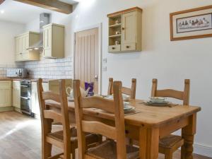 a kitchen and dining room with a wooden table and chairs at Apple Tree Barn- Uk40791 in Church Minshull