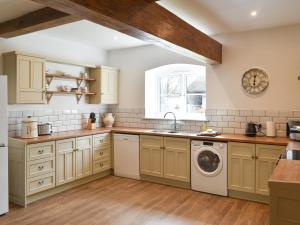 a kitchen with a sink and a washing machine at Apple Tree Barn- Uk40791 in Church Minshull +10 photos