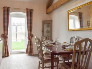 a dining room with a table and chairs and a mirror at Apple Tree Barn- Uk40791 in Church Minshull
